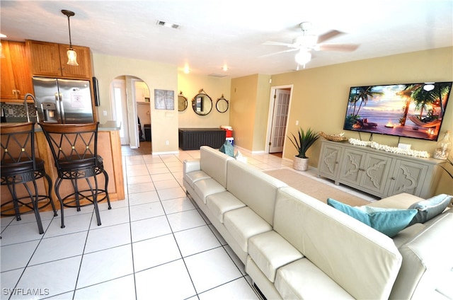 tiled living room with ceiling fan