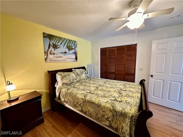 bedroom featuring wood-type flooring, ceiling fan, and a closet