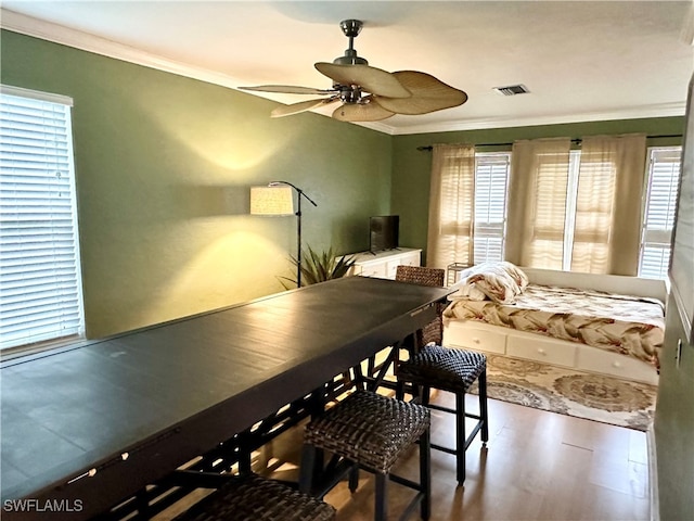 dining room featuring ornamental molding, hardwood / wood-style floors, ceiling fan, and a healthy amount of sunlight