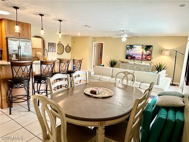 dining room with ceiling fan, sink, and light tile patterned floors