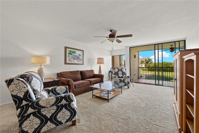 living room with a textured ceiling, a wall of windows, ceiling fan, and carpet