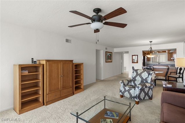 carpeted living room with ceiling fan