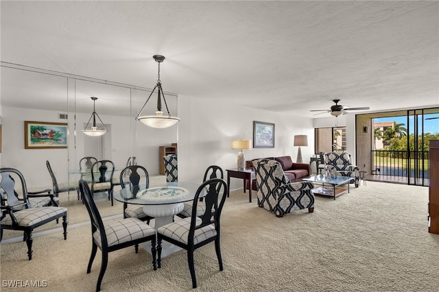 dining space with a textured ceiling, ceiling fan, and carpet flooring