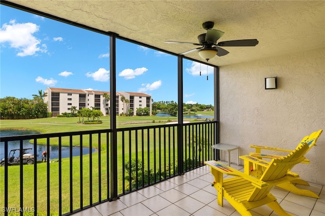 unfurnished sunroom featuring ceiling fan and a water view