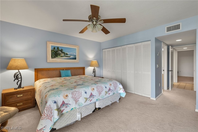 bedroom featuring light colored carpet, ceiling fan, and a closet