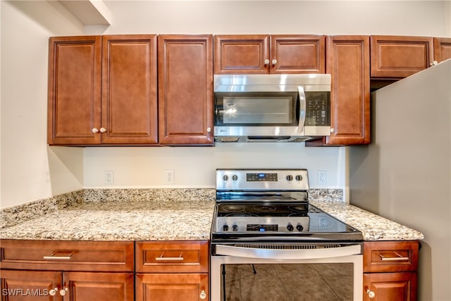 kitchen with appliances with stainless steel finishes and light stone countertops