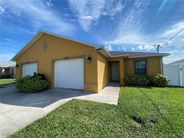 ranch-style home featuring driveway, an attached garage, fence, a front lawn, and stucco siding