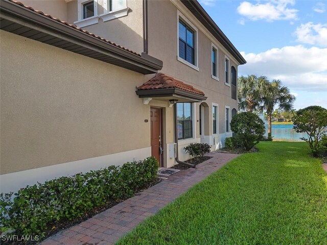 exterior space with a water view and a lawn