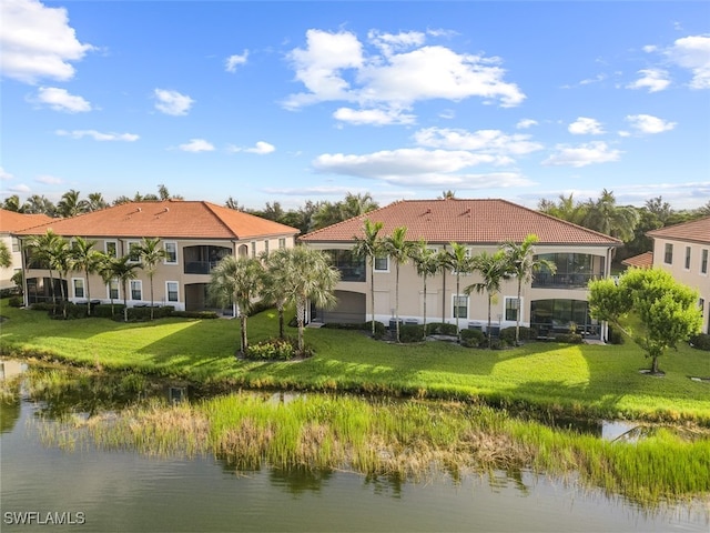 rear view of property featuring a water view and a yard