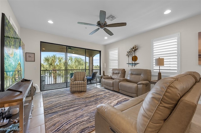 living room with light tile patterned floors, ceiling fan, and a wealth of natural light