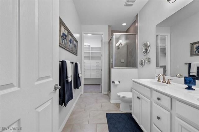 bathroom featuring a shower with door, vanity, toilet, and tile patterned flooring