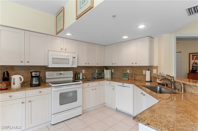 kitchen featuring light stone countertops, white appliances, backsplash, sink, and white cabinetry