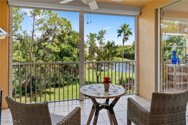 sunroom featuring plenty of natural light, a water view, and ceiling fan