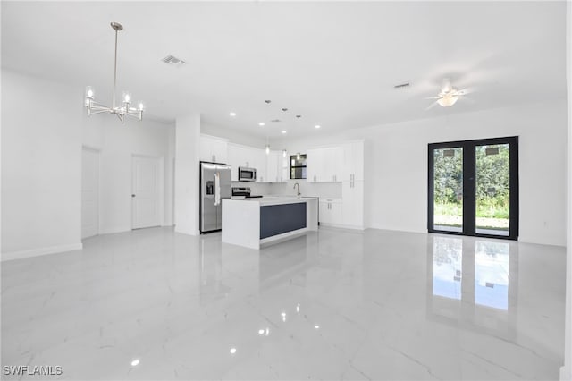 unfurnished living room featuring ceiling fan with notable chandelier and sink