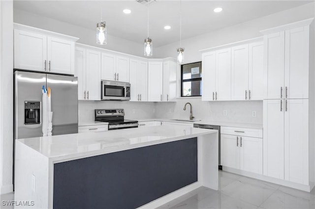 2602 73rd St W, Lehigh Acres, FL 33971 - kitchen featuring a sink, pendant lighting, appliances with stainless steel finishes, a center island, and white cabinets