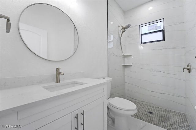 bathroom featuring tiled shower, toilet, and vanity