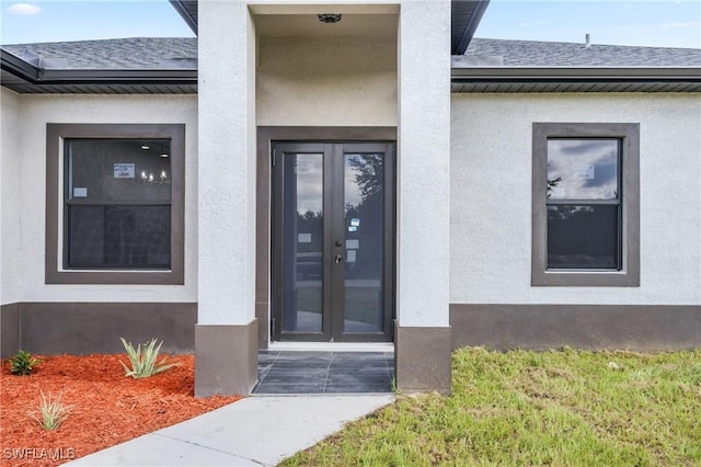 2602 73rd St W, Lehigh Acres, FL 33971 - entrance to property with stucco siding, french doors, and roof with shingles