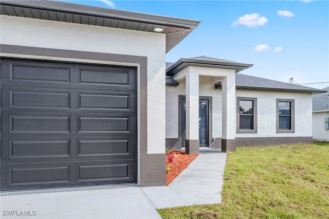 doorway to property featuring a yard and a garage