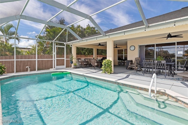 view of swimming pool with an outdoor living space, ceiling fan, a patio, and a lanai