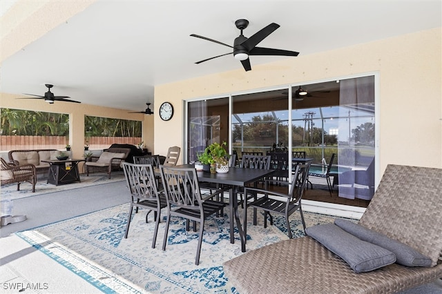 view of patio with glass enclosure, ceiling fan, and an outdoor hangout area