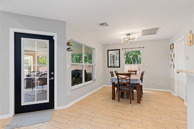 dining space featuring a notable chandelier and light hardwood / wood-style floors