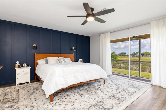 bedroom with hardwood / wood-style floors, ceiling fan, and access to exterior