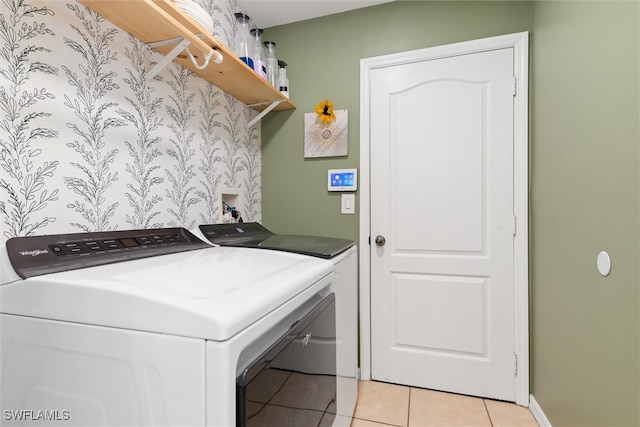 clothes washing area featuring washing machine and dryer and light tile patterned floors