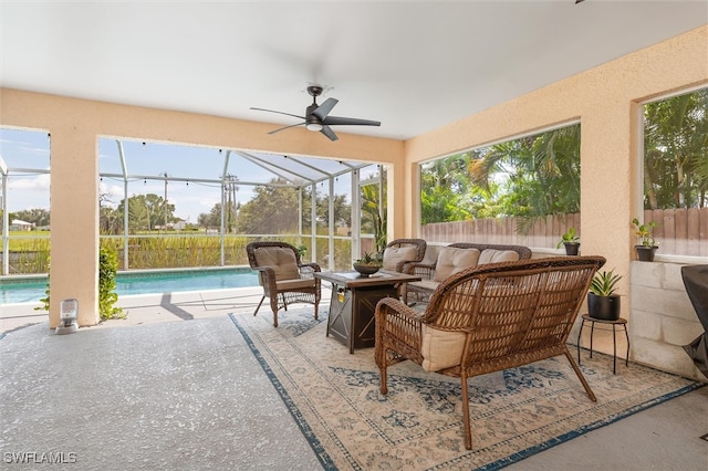 sunroom with ceiling fan and a pool