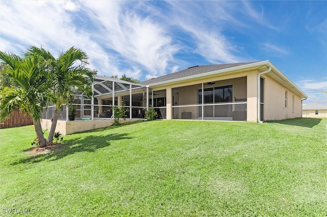 rear view of house featuring a lanai and a yard