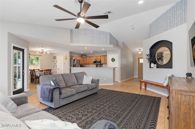 living room featuring light wood-type flooring, ceiling fan, and high vaulted ceiling