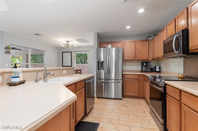 kitchen featuring tasteful backsplash, sink, appliances with stainless steel finishes, and light hardwood / wood-style floors