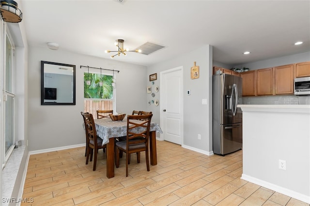 dining room featuring light wood-type flooring and a chandelier