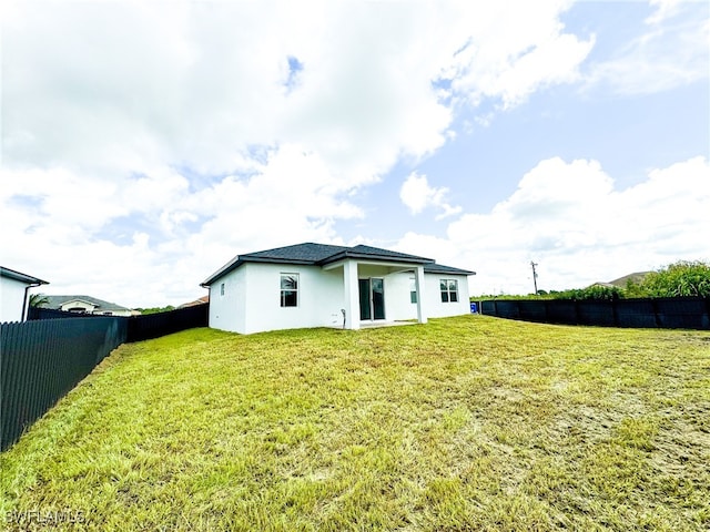 rear view of house with a yard