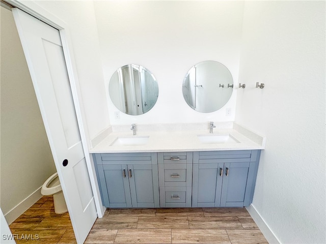 bathroom featuring vanity, toilet, and hardwood / wood-style floors