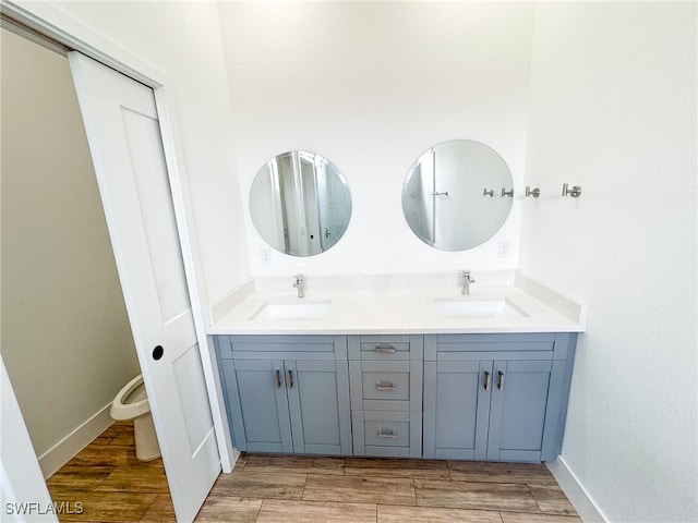 bathroom featuring toilet, hardwood / wood-style flooring, and vanity