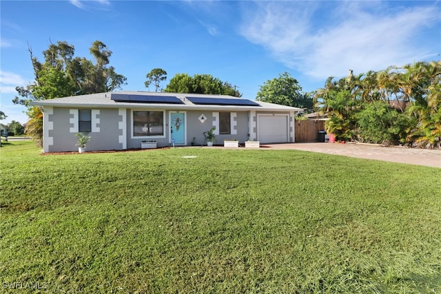 ranch-style home featuring a front yard, a garage, and solar panels