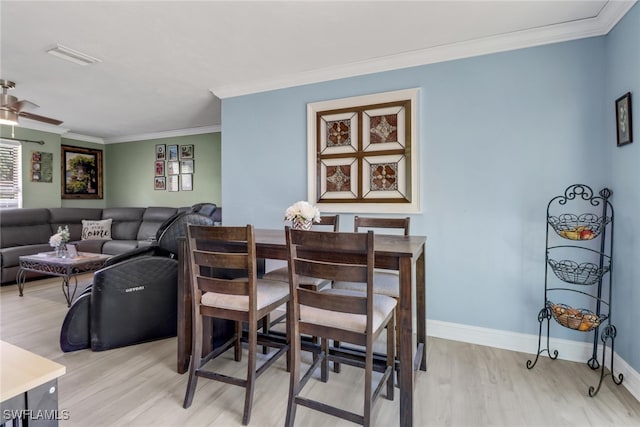 dining space featuring crown molding, ceiling fan, and light hardwood / wood-style flooring