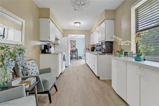 kitchen with light hardwood / wood-style flooring, white cabinets, and white appliances