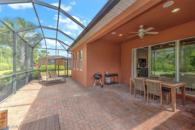 view of patio featuring ceiling fan and glass enclosure