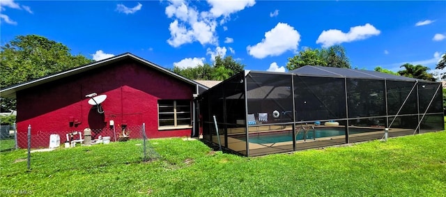 exterior space featuring glass enclosure and a lawn