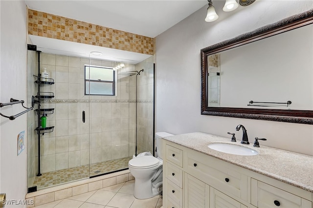 bathroom featuring toilet, vanity, tile patterned floors, and a shower with door