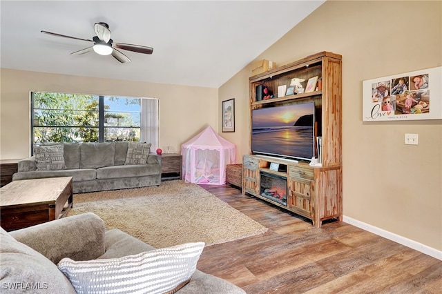 living room featuring ceiling fan, wood-type flooring, and vaulted ceiling