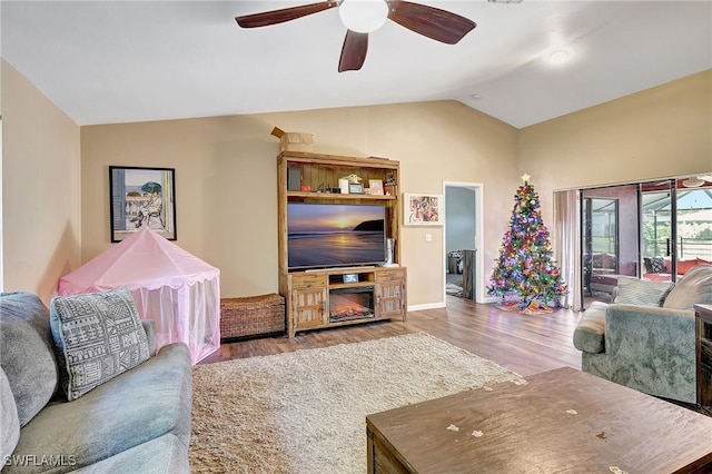 living room featuring ceiling fan, light hardwood / wood-style floors, and vaulted ceiling