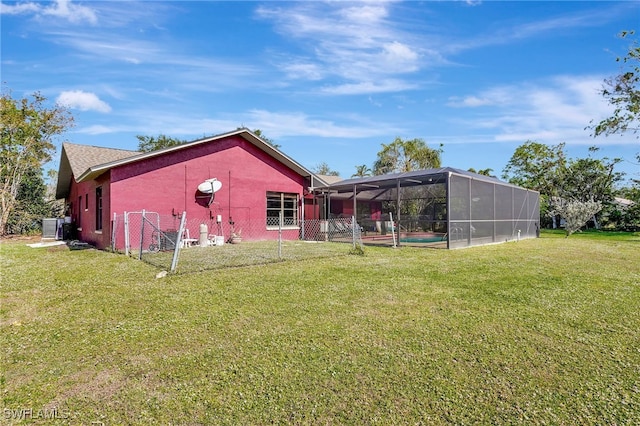 back of property with a pool, a lanai, and a lawn