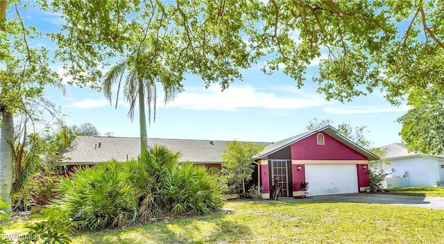 ranch-style house featuring a front lawn and a garage