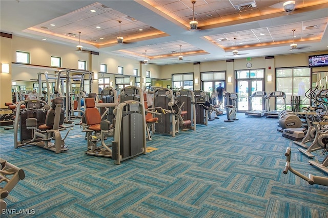 exercise room featuring carpet, a raised ceiling, and coffered ceiling