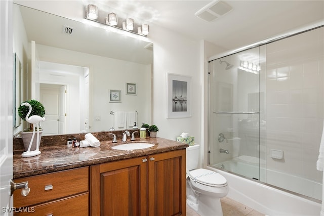 full bathroom with bath / shower combo with glass door, vanity, toilet, and tile patterned floors