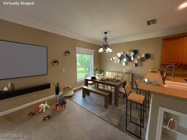 carpeted dining area with ornamental molding, a chandelier, and sink