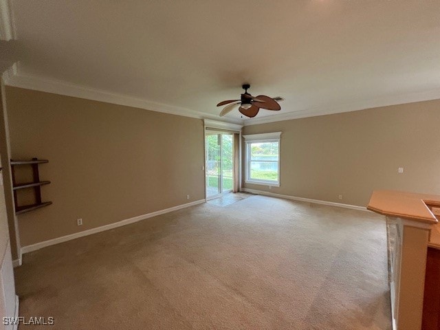 carpeted spare room featuring ornamental molding and ceiling fan