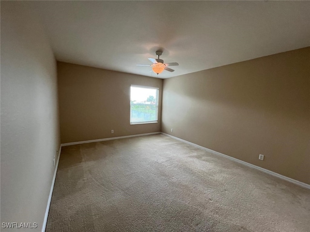 carpeted spare room featuring ceiling fan